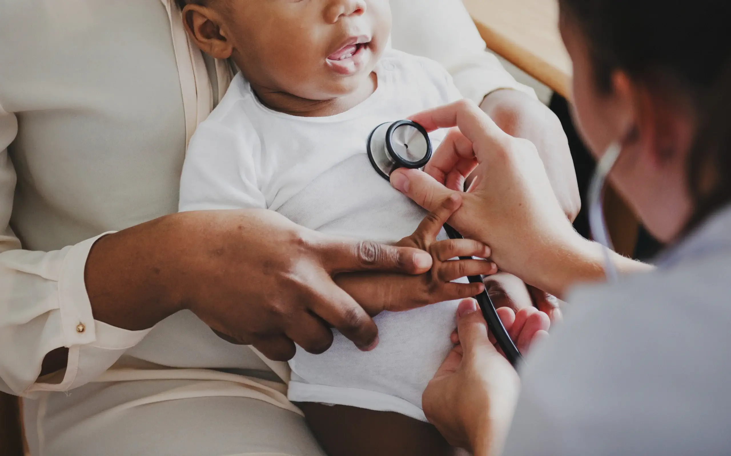 Consultation en pédiatrie sociale avec un bébé pris en charge par un professionnel de santé.